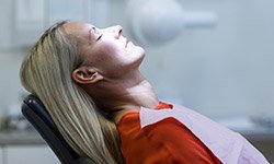 Relaxed woman with eyes closed in dental chair