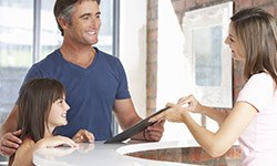 Man and child checking in at reception desk