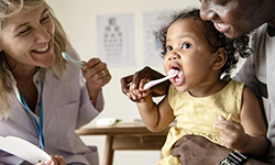 children’s dentist in Middleburg Heights showing little girl how to brush her teeth