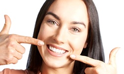 woman pointing to her teeth after visiting her cosmetic dentist in Middleburg Heights