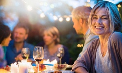 Woman smiling with dental bridge in Middleburg Heights at dinner party