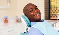 Male patient sitting back and smiling after receiving dental implants in Cleveland, OH