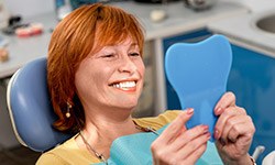 Senior woman looking at smile in mirror