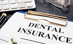 dental insurance form on a blue clipboard 