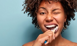 Woman brushing teeth in Middleburg Heights