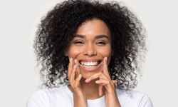 person smiling and holding dental floss up to their mouth