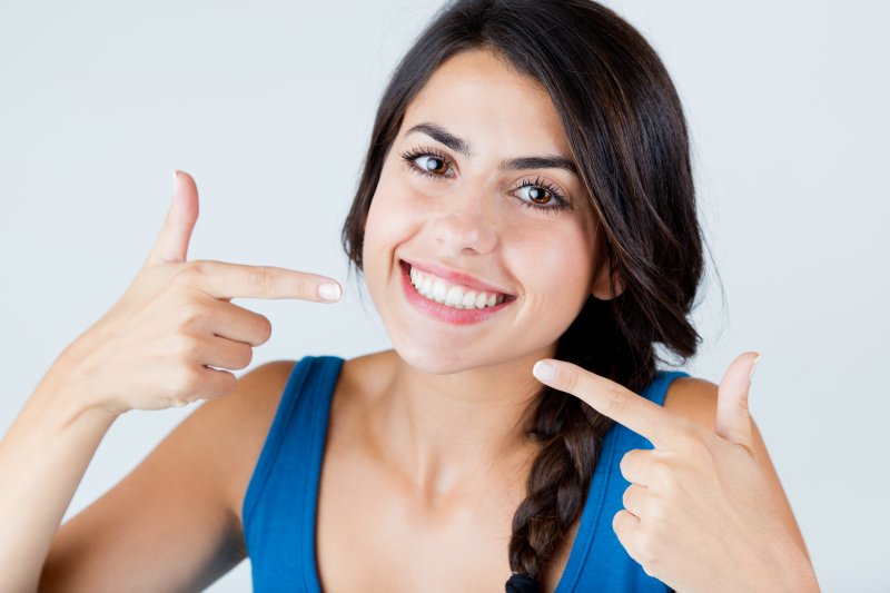 young woman pointing to white smile 