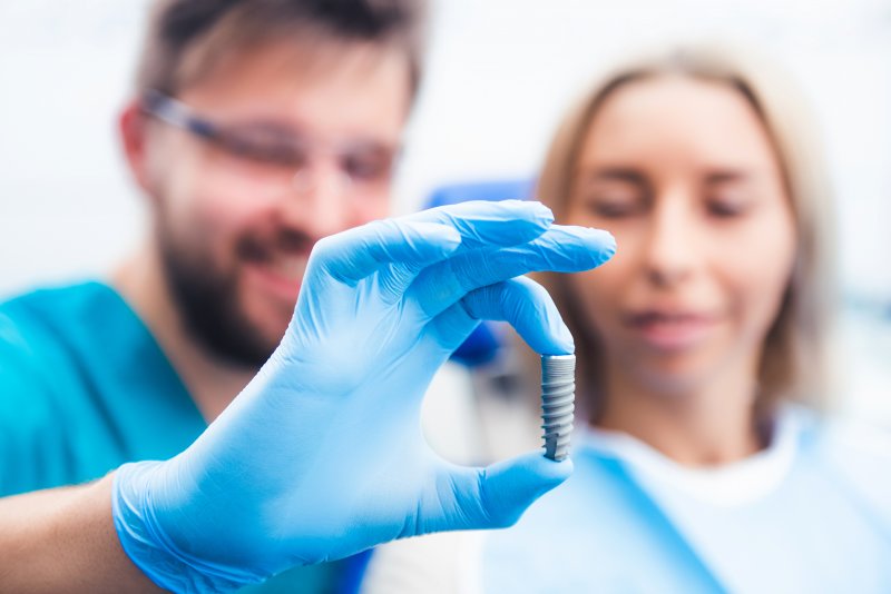 dentist showing patient dental implant