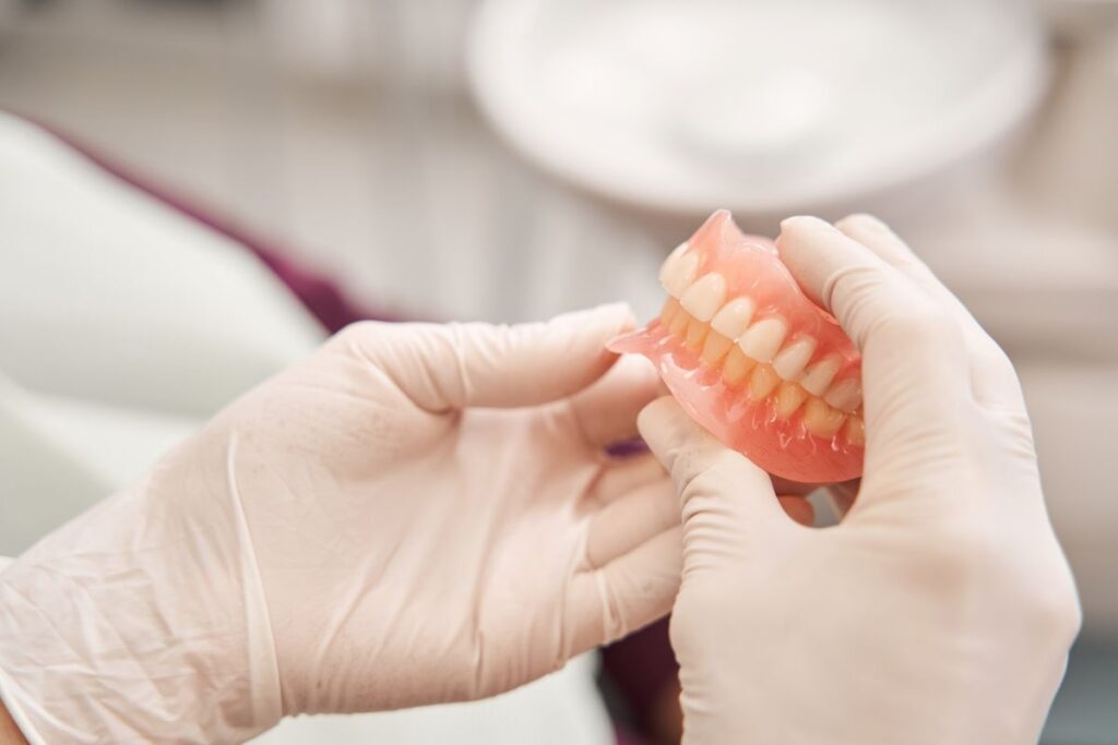 A dentist holding a pair of dentures